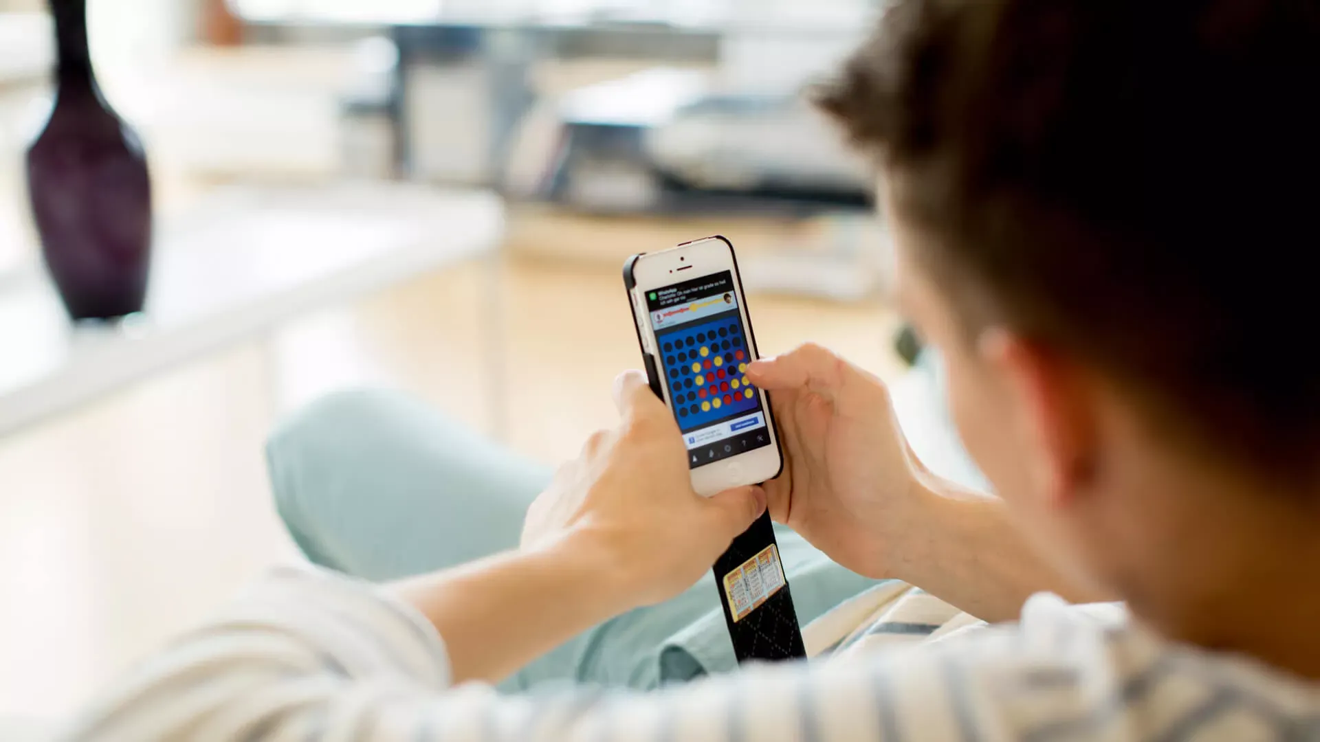 Jugendlicher sitzt auf Sofa und spielt ein Computerspiel auf seinem Smartphone. – Bildnachweis: wdv.de © Szekely.Oana Jugendlicher sitzt auf Sofa und spielt ein Computerspiel auf seinem Smartphone. – Bildnachweis: wdv.de © Szekely.Oana