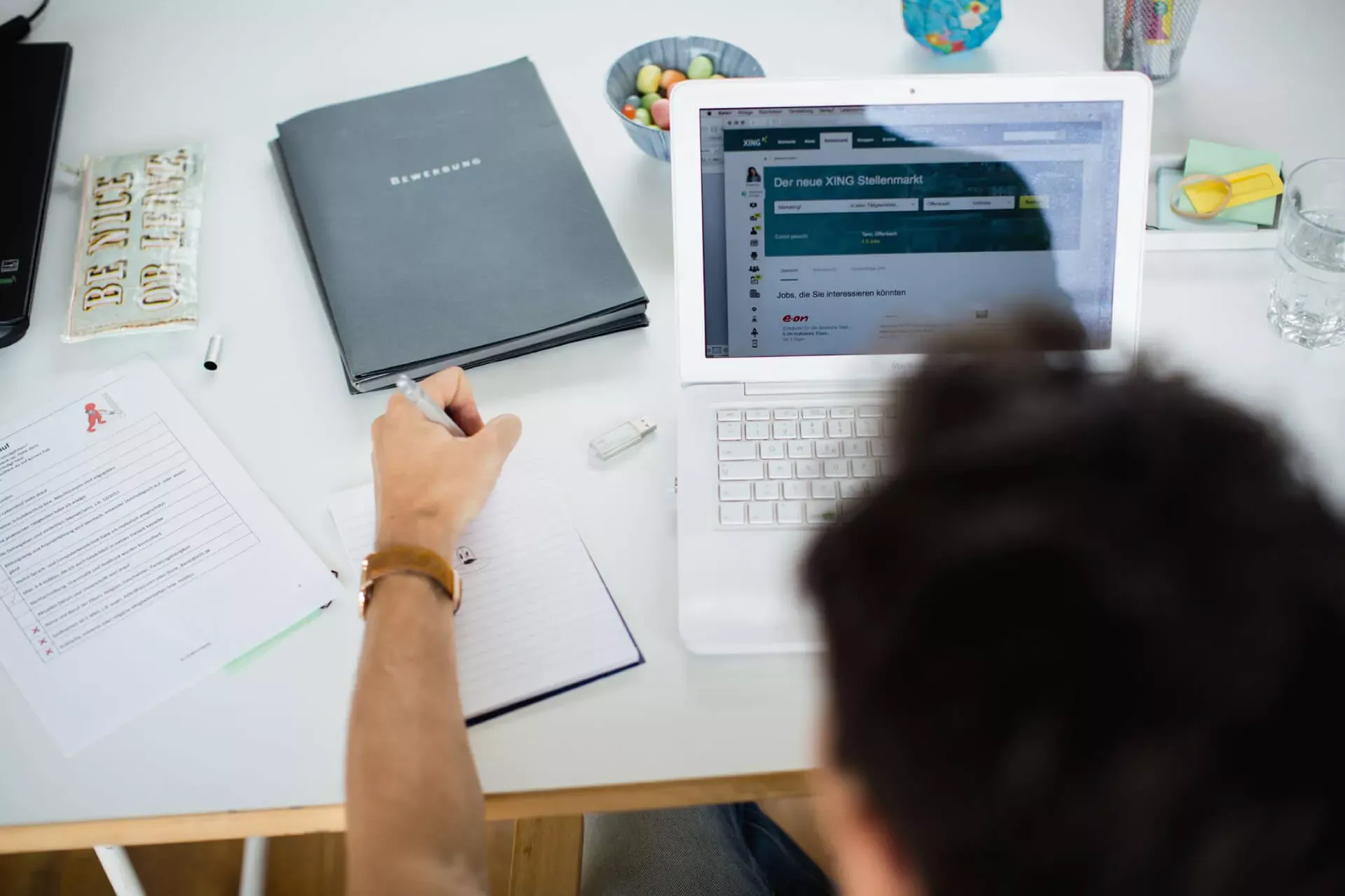 Mann auf Jobsuche im Internet, mit Bewerbungsunterlagen auf dem Tisch. Mann auf Jobsuche im Internet, mit Bewerbungsunterlagen auf dem Tisch.