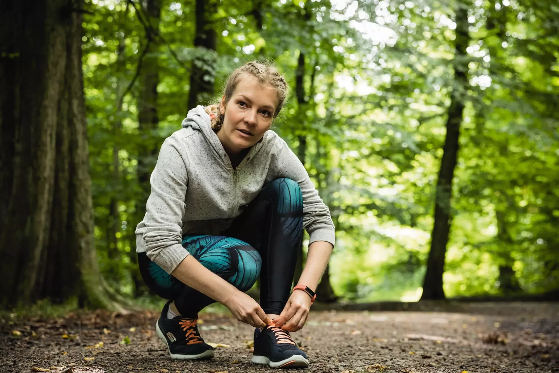 Junge Frau schnürt Laufschuh im Wald. Junge Frau schnürt Laufschuh im Wald.