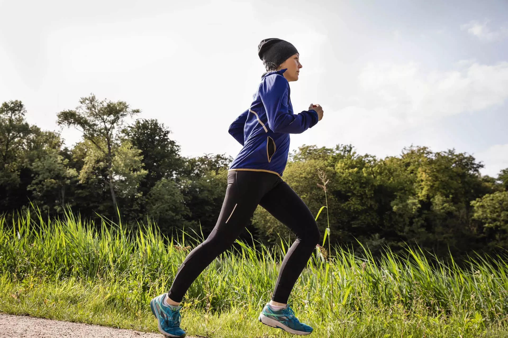 Junge Frau beim Joggen in langer Kleidung mit Mütze. Junge Frau beim Joggen in langer Kleidung mit Mütze.