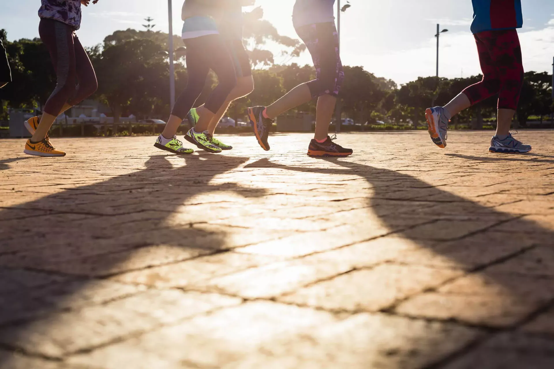 Beine von Joggern auf gepflastertem Weg Beine von Joggern auf gepflastertem Weg